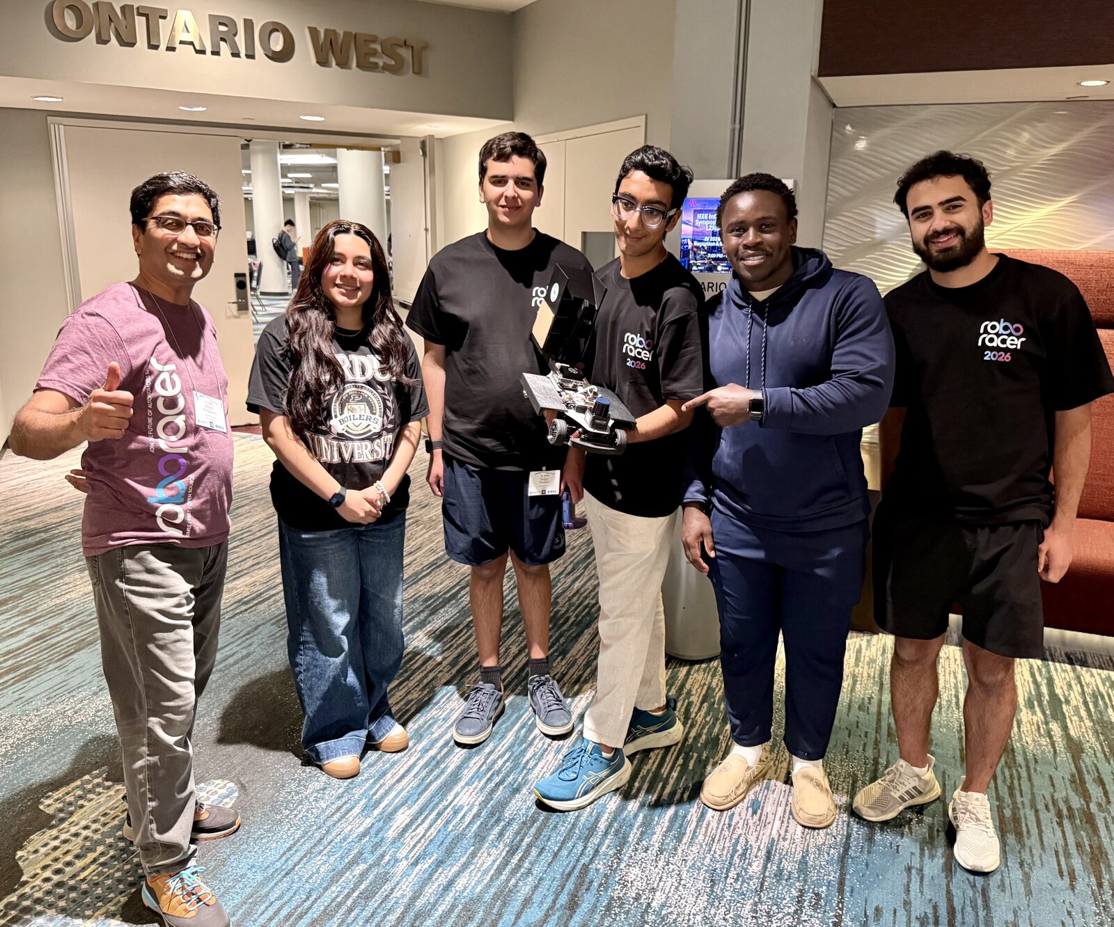 Roboracer @ Purdue board members holding Car 2 at the competition venue